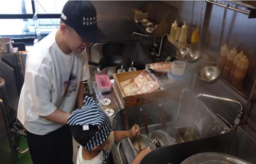 神奈川県・東京多摩エリアで展開する鶏とんこつ醤油ラーメン店「七志」では、毎月開催している体験型イベント「大人ラーメン教室」「親子ラーメン教室」が好評を博しています。運営する株式会社ナナシフードサービス(本社:横浜市青葉区)によると、累計受講者数は5,000人を突破し、昨年度比で150%の増加を記録したそうです。写真は教室に参加したお子さまがラーメンをゆでる様子